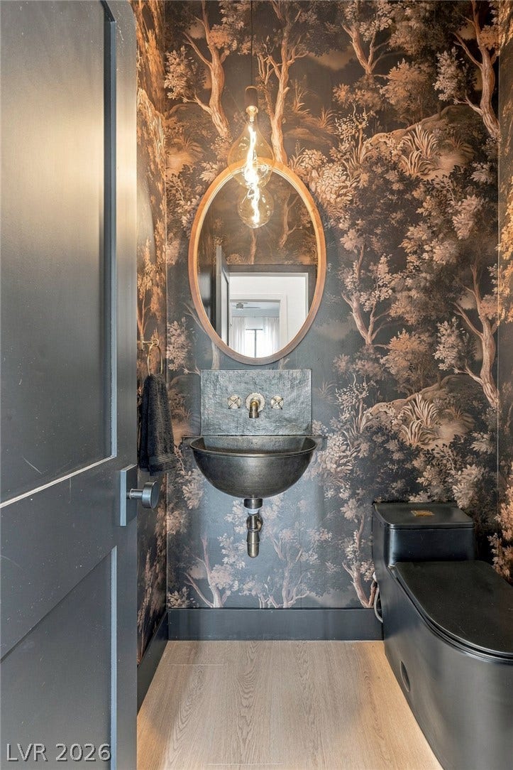 40 Stonemark Drive, Henderson, NV 89052 Artistic forest wallpaper and a metallic vessel sink create a memorable powder room experience.