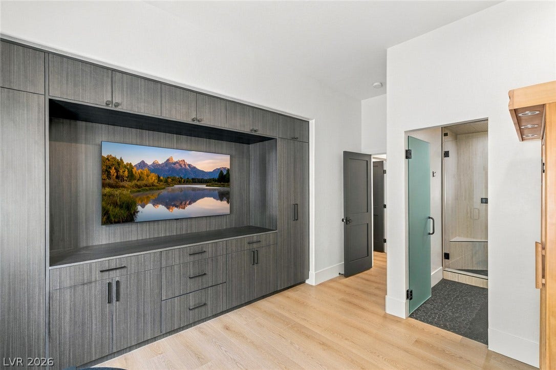 40 Stonemark Drive, Henderson, NV 89052 Custom built-in cabinetry and warm wood flooring frame a modern home gym or recreation area.