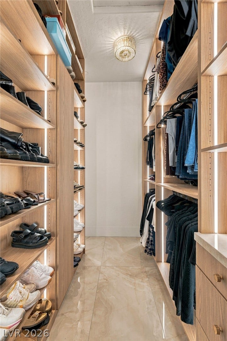 40 Stonemark Drive, Henderson, NV 89052 Custom oak cabinetry and integrated strip lighting define this meticulously organized walk-in closet space.