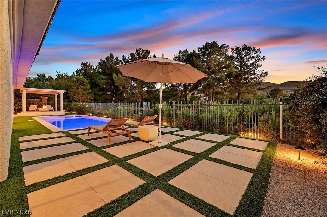 12007 Oakland Hills Drive, Las Vegas, NV 89141 An inviting backyard oasis features modern pavers, a shimmering pool, and mature trees.