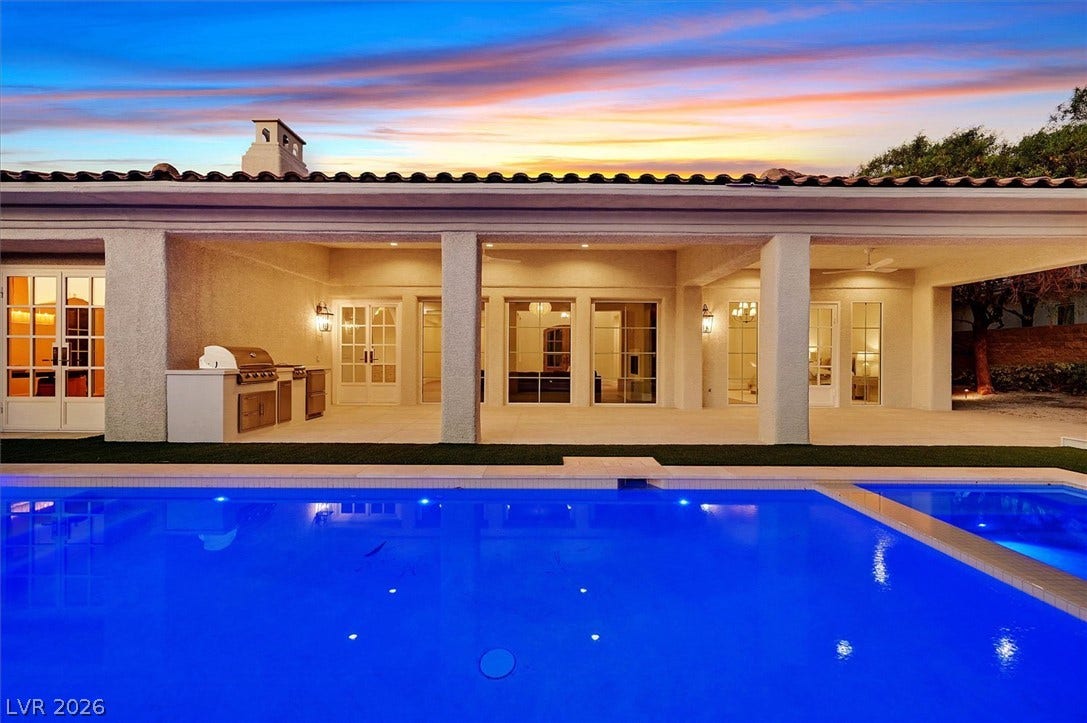12007 Oakland Hills Drive, Las Vegas, NV 89141 A deep blue swimming pool sits steps from a covered terrace featuring a built-in summer kitchen.