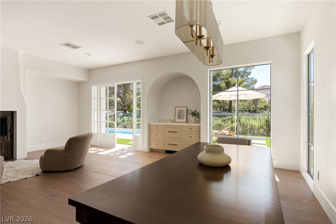 12007 Oakland Hills Drive, Las Vegas, NV 89141 Hardwood floors and massive windows frame views of the pool from this dining area.