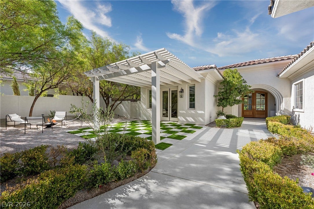 12007 Oakland Hills Drive, Las Vegas, NV 89141 An inviting courtyard path leads past a custom pergola toward the arched double-door entry.