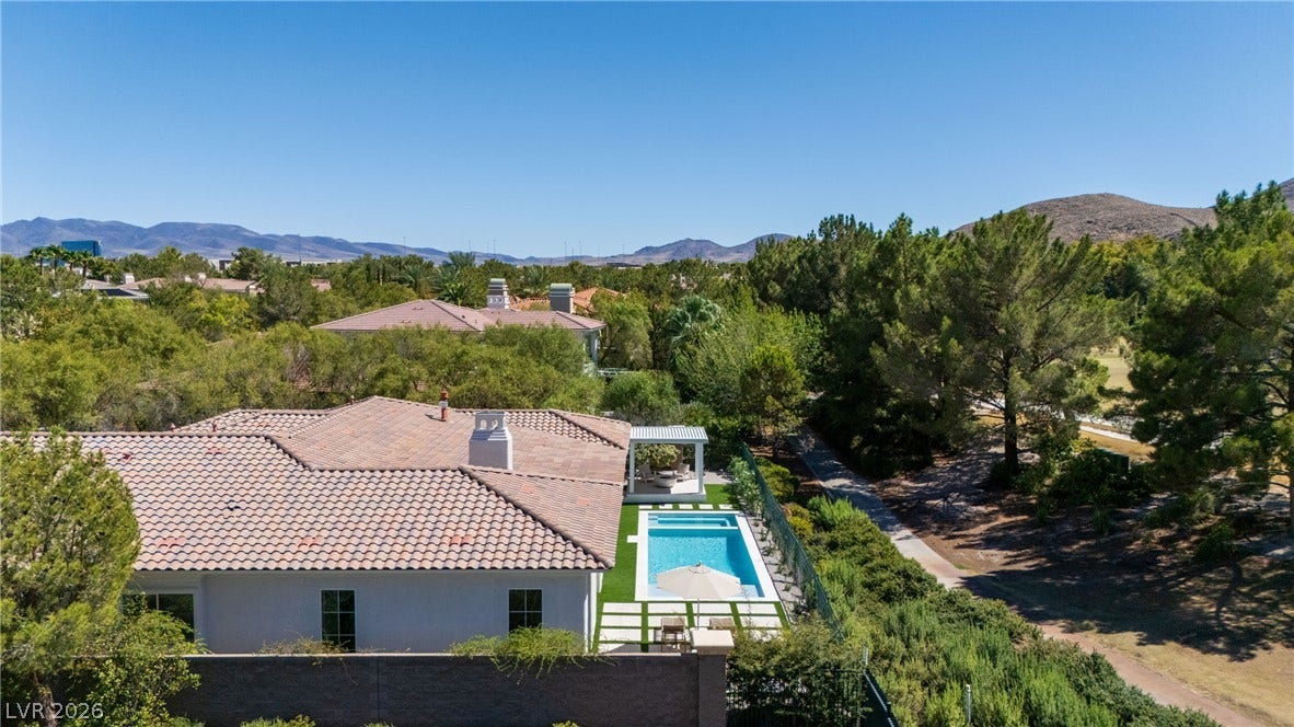 12007 Oakland Hills Drive, Las Vegas, NV 89141 An aerial perspective showcases the tiled rooflines, private swimming pool, and scenic mountain backdrop.