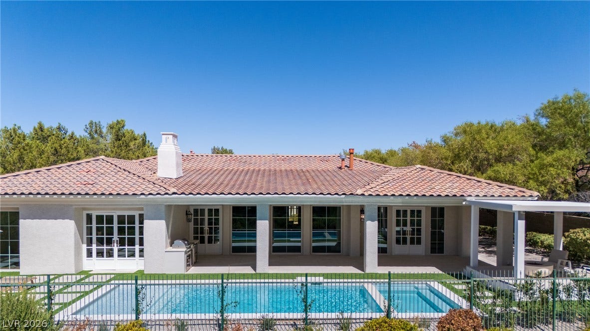 12007 Oakland Hills Drive, Las Vegas, NV 89141 Spanish tile roofing highlights this elegant rear elevation featuring a classic pool and patio.