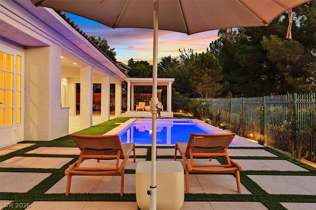 12007 Oakland Hills Drive, Las Vegas, NV 89141 An inviting swimming pool sparkles under a sunset sky next to the covered patio.