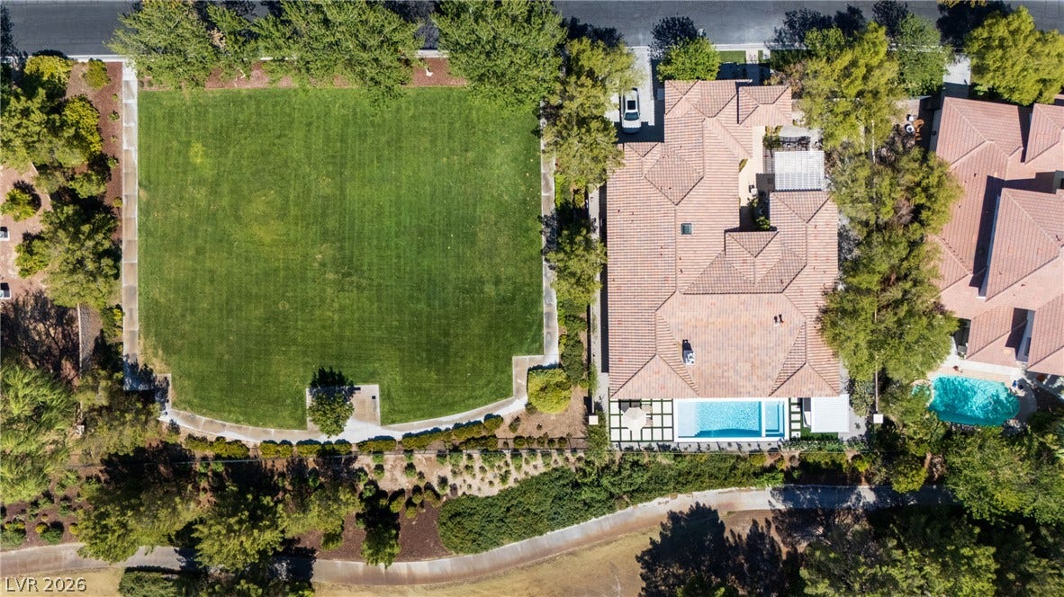 12007 Oakland Hills Drive, Las Vegas, NV 89141 An expansive manicured lawn and a private swimming pool border this tile-roofed estate.