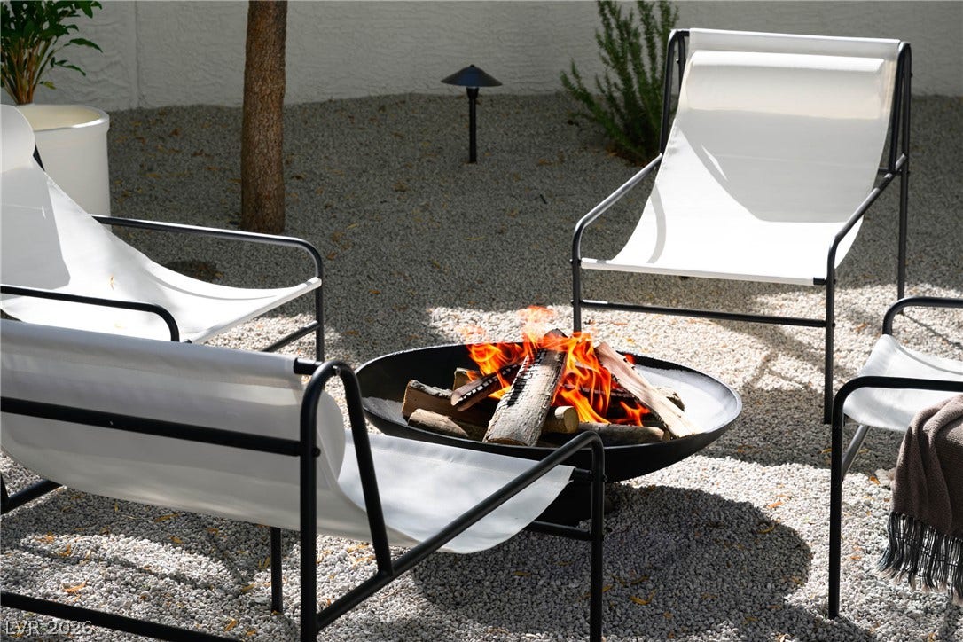 12007 Oakland Hills Drive, Las Vegas, NV 89141 Gravel ground cover defines this cozy outdoor gathering space centered around a circular metal fire pit.