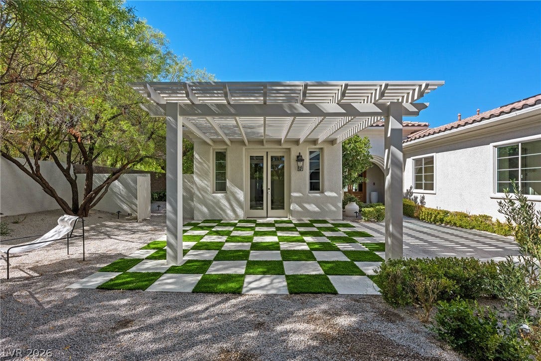 12007 Oakland Hills Drive, Las Vegas, NV 89141 A custom white pergola stands over a checkered paver patio alongside French doors.