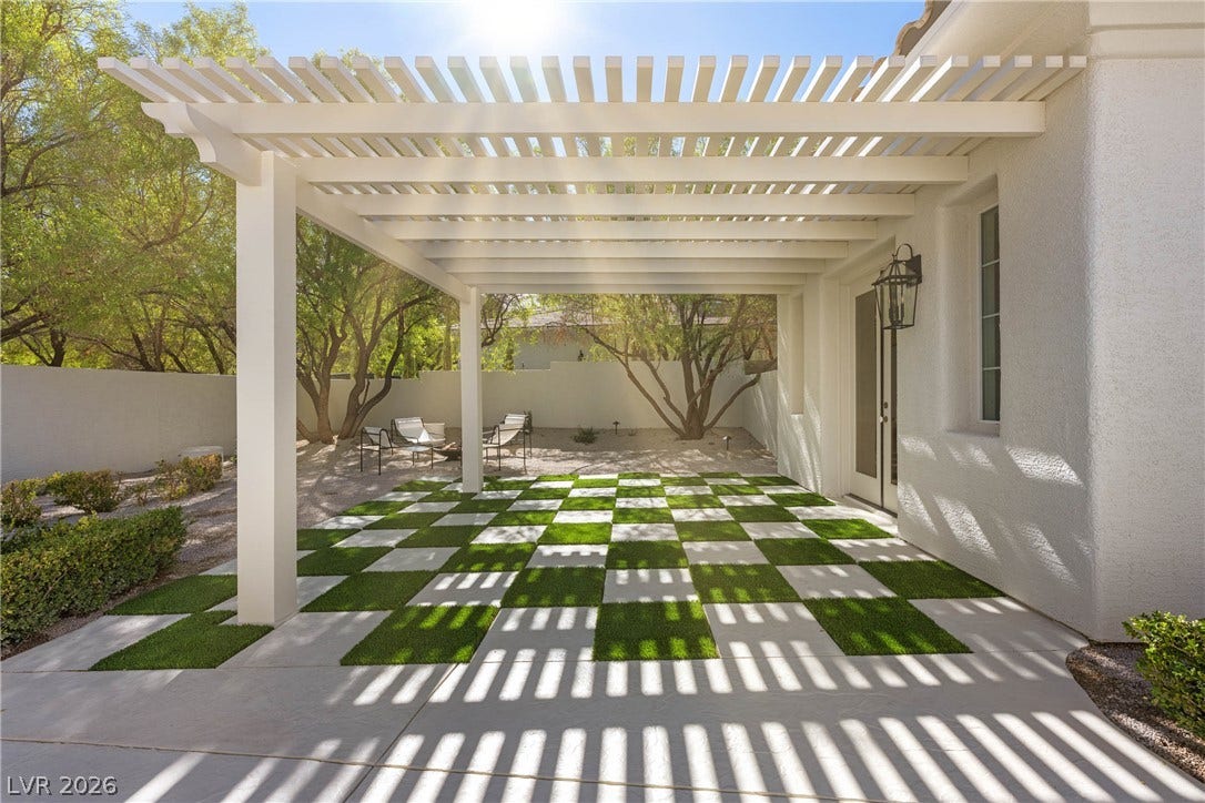 12007 Oakland Hills Drive, Las Vegas, NV 89141 An elegant white pergola shades a uniquely patterned paver and turf patio courtyard.
