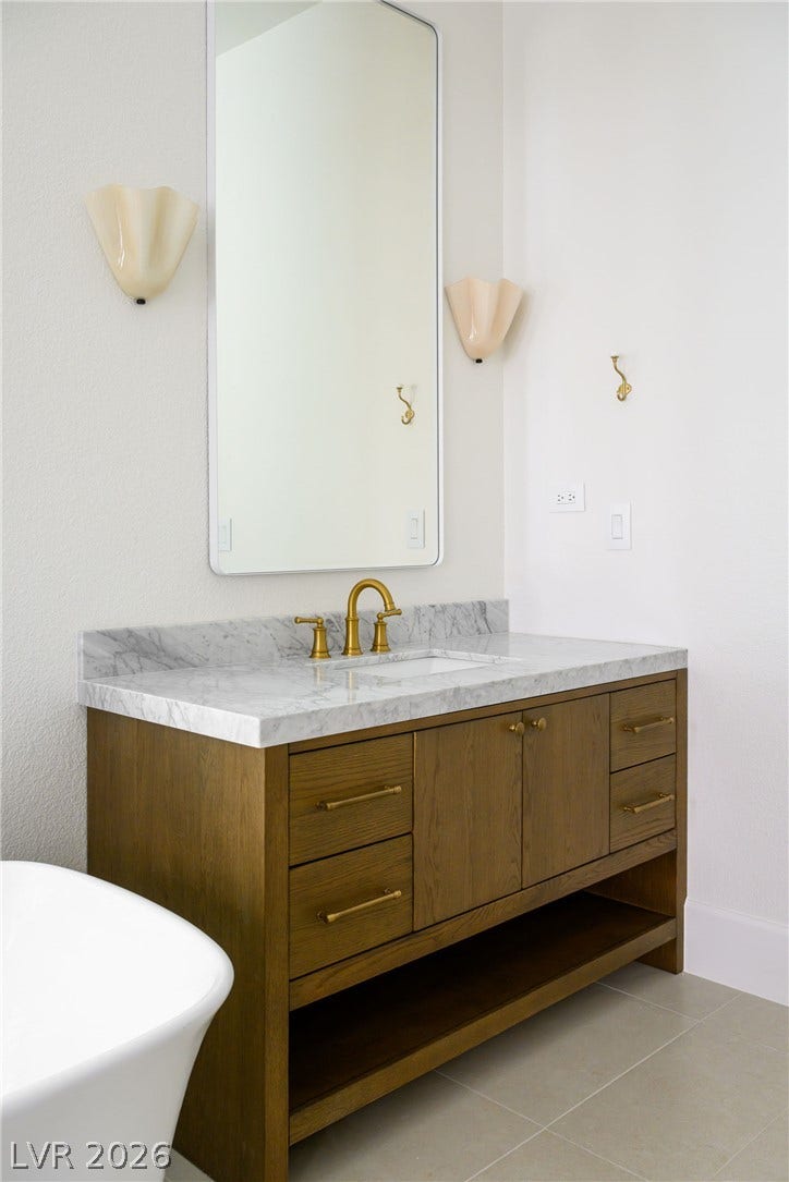 12007 Oakland Hills Drive, Las Vegas, NV 89141 Rich wood and sleek stone create an inviting modern vanity setup.