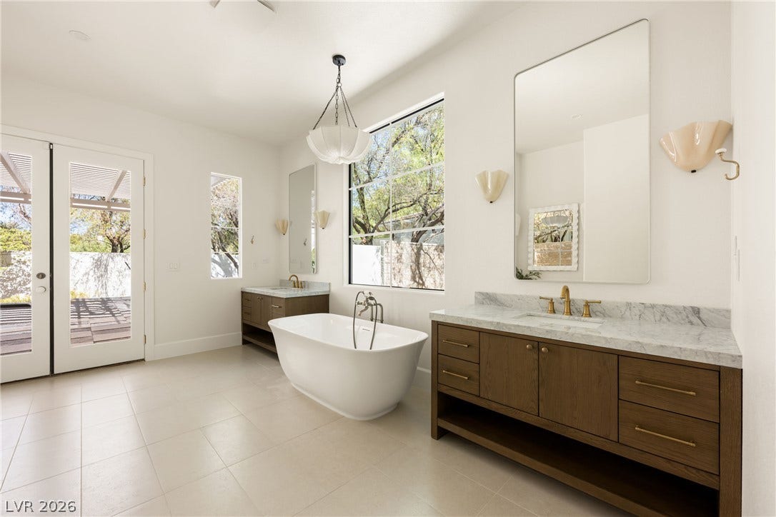 12007 Oakland Hills Drive, Las Vegas, NV 89141 Stone counters and a freestanding soaking tub anchor this airy, light-filled bathroom.