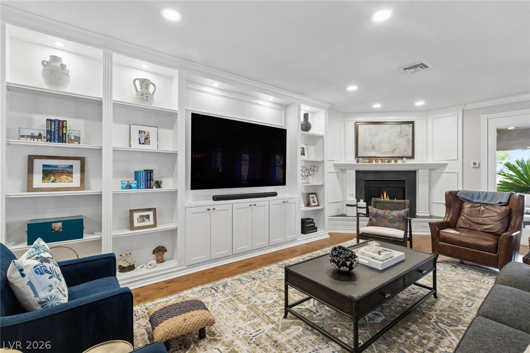 9916 Aspen Knoll Court, Las Vegas, NV 89117 Custom built-ins and a classic fireplace anchor this inviting living space.