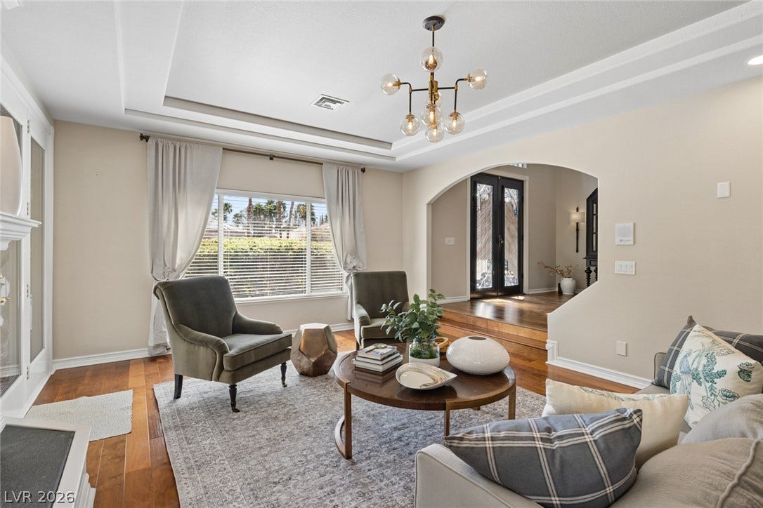 9916 Aspen Knoll Court, Las Vegas, NV 89117 Rich hardwood flooring and a stylish tray ceiling elevate this elegant formal living room.