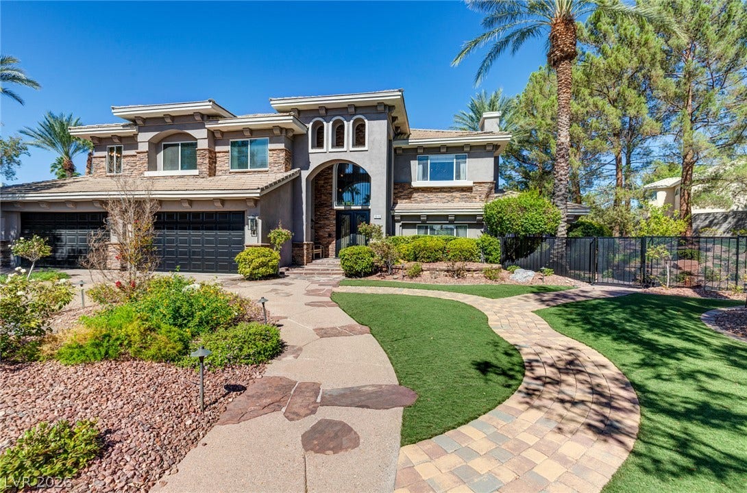 9916 Aspen Knoll Court, Las Vegas, NV 89117 A stone-paved path winds toward the grand arched entrance of this home. Gated side yard shows the 1/2 acre property at left .