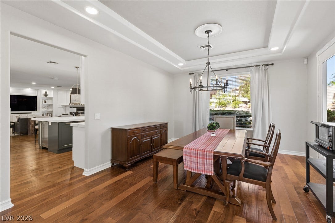 9916 Aspen Knoll Court, Las Vegas, NV 89117 Polished hardwood floors and a recessed tray ceiling define this open formal dining space. Kitchen & Family room at left.