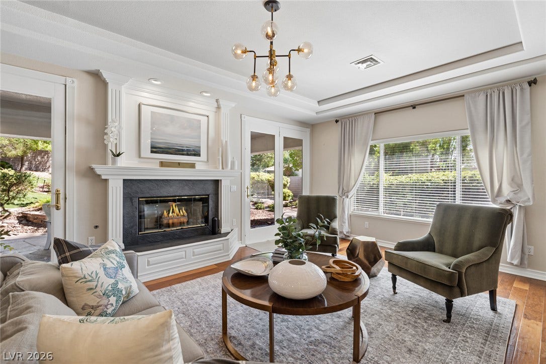 9916 Aspen Knoll Court, Las Vegas, NV 89117 A classic fireplace with a detailed mantel anchors this living space beneath a tray ceiling.