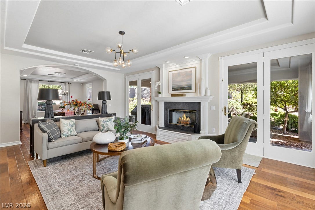 9916 Aspen Knoll Court, Las Vegas, NV 89117 Rich wood flooring, coffered ceilings and a classic fireplace anchor this elegant, light-filled gathering space.