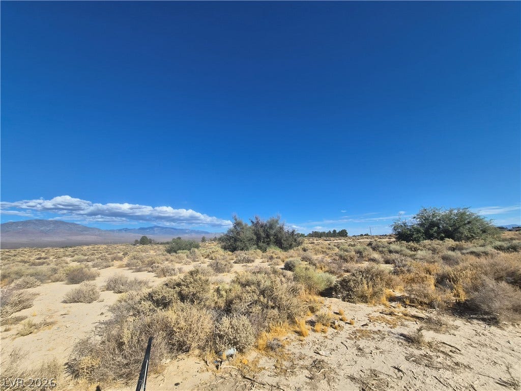 4221 N Leslie Street, Pahrump, NV 89060 Distant mountains frame this vast desert lot under an expansive blue sky.