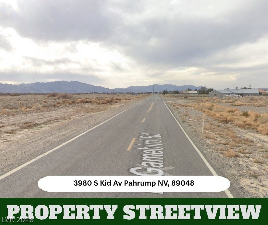 Distant mountains frame a paved road stretching through the serene desert landscape.