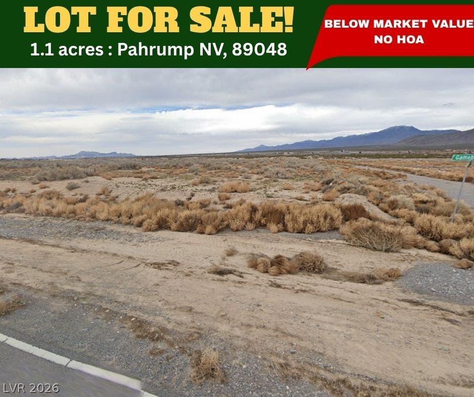 Panoramic mountain views surround this expansive desert parcel situated along a paved access road.