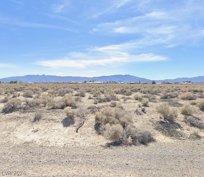 1101 E Highland Avenue, Pahrump, NV 89048 Panoramic mountain and desert vistas stretch across this open building lot under clear blue skies.
