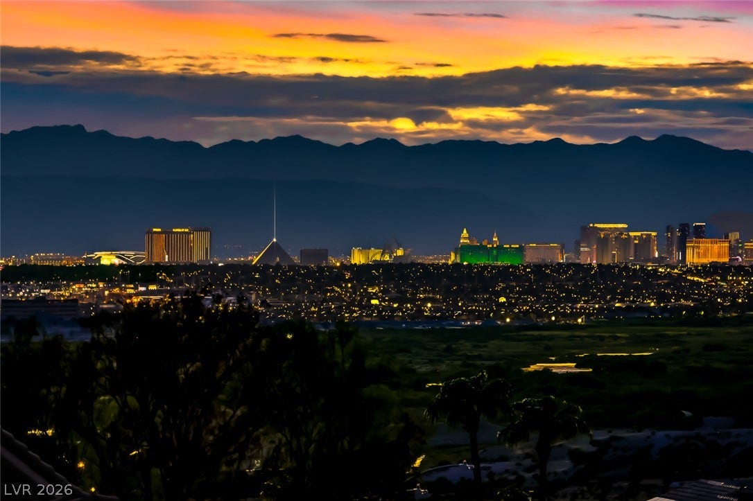 1157 Big Bird Court, Henderson, NV 89011 Distant mountains frame a sparkling city skyline set against a dramatic sunset sky.