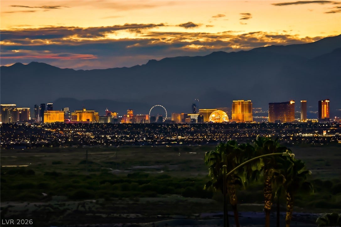 1157 Big Bird Court, Henderson, NV 89011 Dramatic mountain silhouettes frame a glittering city skyline under a golden sunset sky.