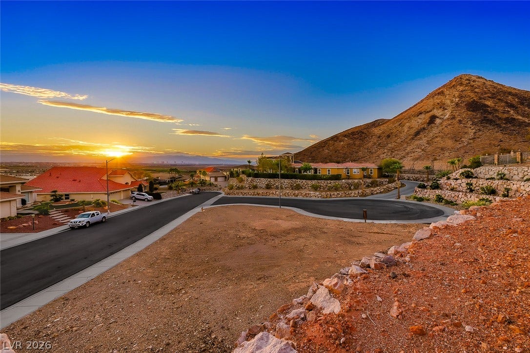 1157 Big Bird Court, Henderson, NV 89011 Dramatic mountain backdrops frame this elevated neighborhood view at sunset.