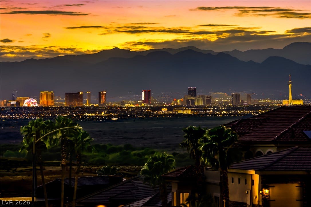 1157 Big Bird Court, Henderson, NV 89011 Dramatic mountain silhouettes frame the glittering city skyline under a golden sunset.