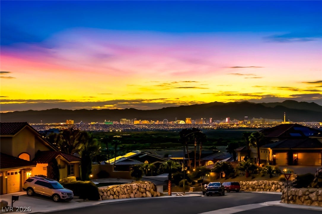1157 Big Bird Court, Henderson, NV 89011 Distant mountains frame a sparkling city skyline beneath a colorful evening sky.