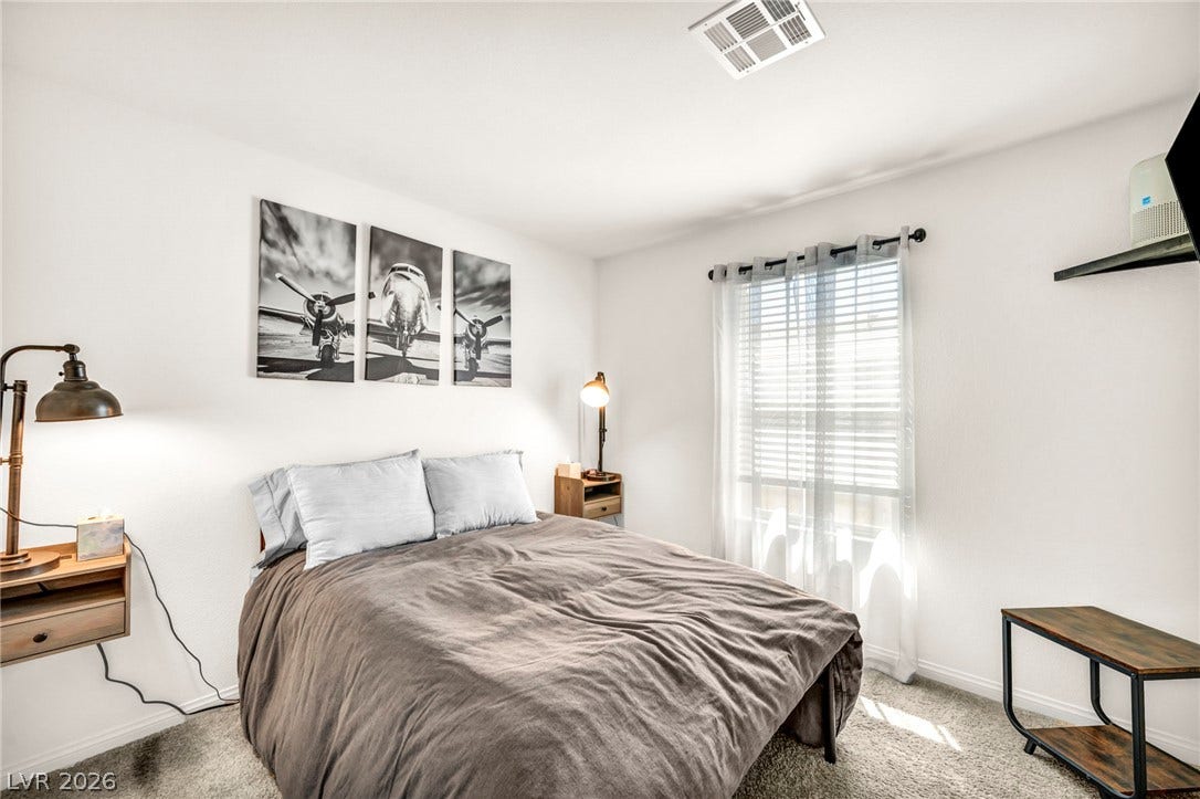 2594 Canary Yellow Court, North Las Vegas, NV 89086 Plush carpeting and natural light flowing through a large window define this cozy bedroom.