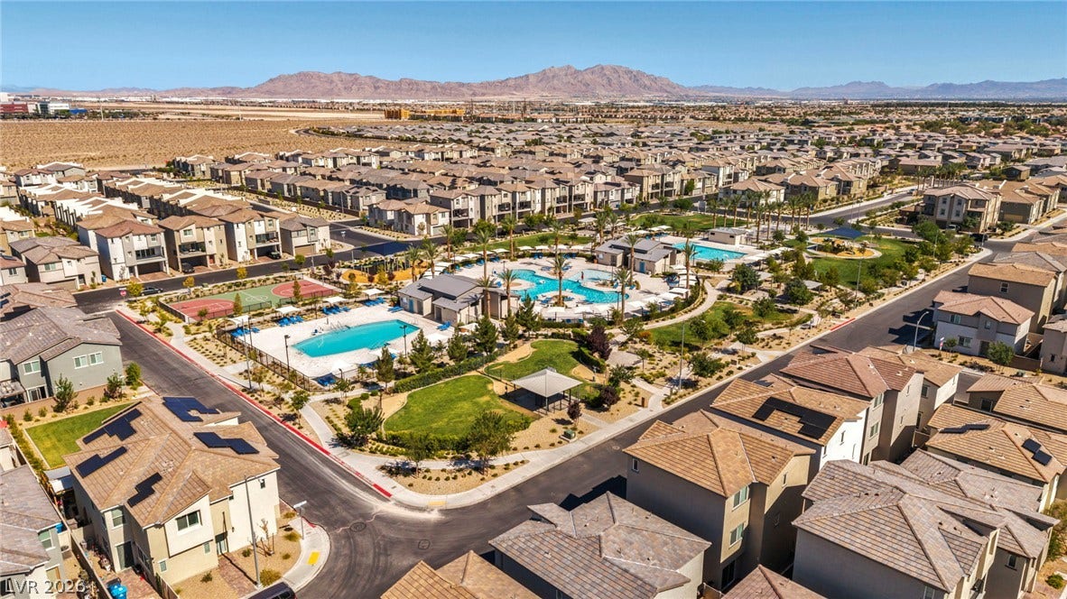 2594 Canary Yellow Court, North Las Vegas, NV 89086 Distant mountains frame a sprawling community featuring multiple pools and manicured green spaces.