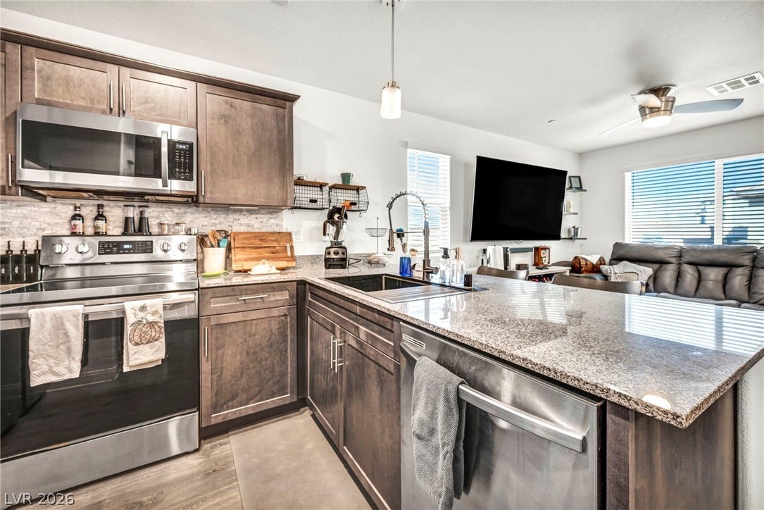 2594 Canary Yellow Court, North Las Vegas, NV 89086 Polished granite countertops and classic wood cabinetry enrich this modern culinary workspace.