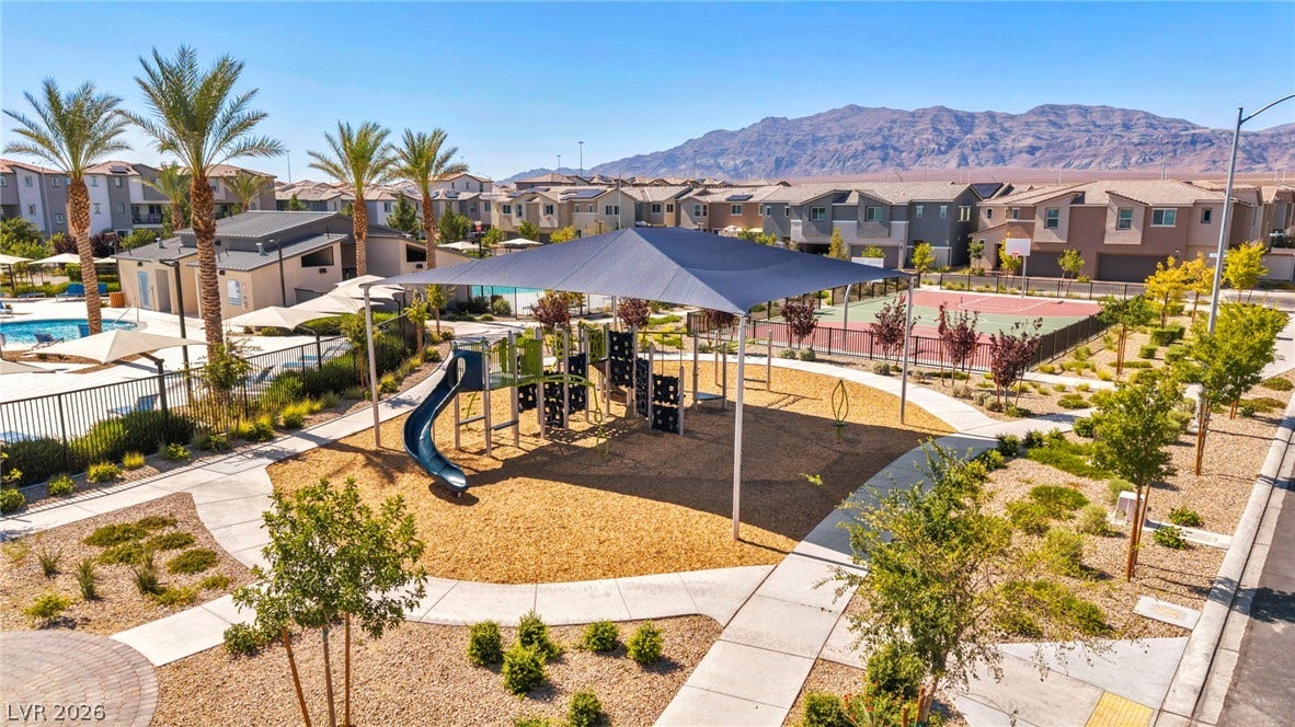 2594 Canary Yellow Court, North Las Vegas, NV 89086 An inviting playground structure under a large shade sail rests within a landscaped community park.