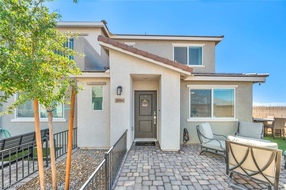 2594 Canary Yellow Court, North Las Vegas, NV 89086 A welcoming stone-paved entryway leads to the modern front door under a clear blue sky.