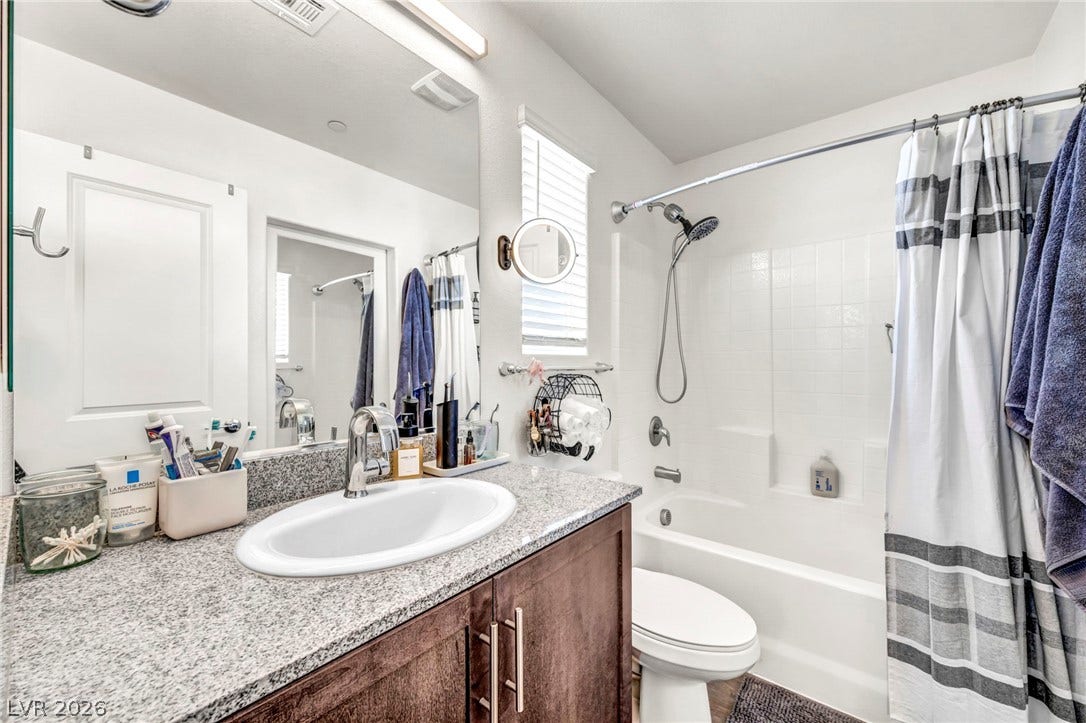 2594 Canary Yellow Court, North Las Vegas, NV 89086 Fine stone countertops elevate the vanity in this functional full bathroom.