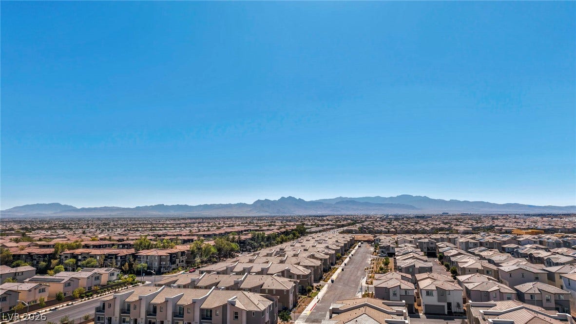 2594 Canary Yellow Court, North Las Vegas, NV 89086 Distant mountain ranges border the surrounding neighborhood under vast blue skies.