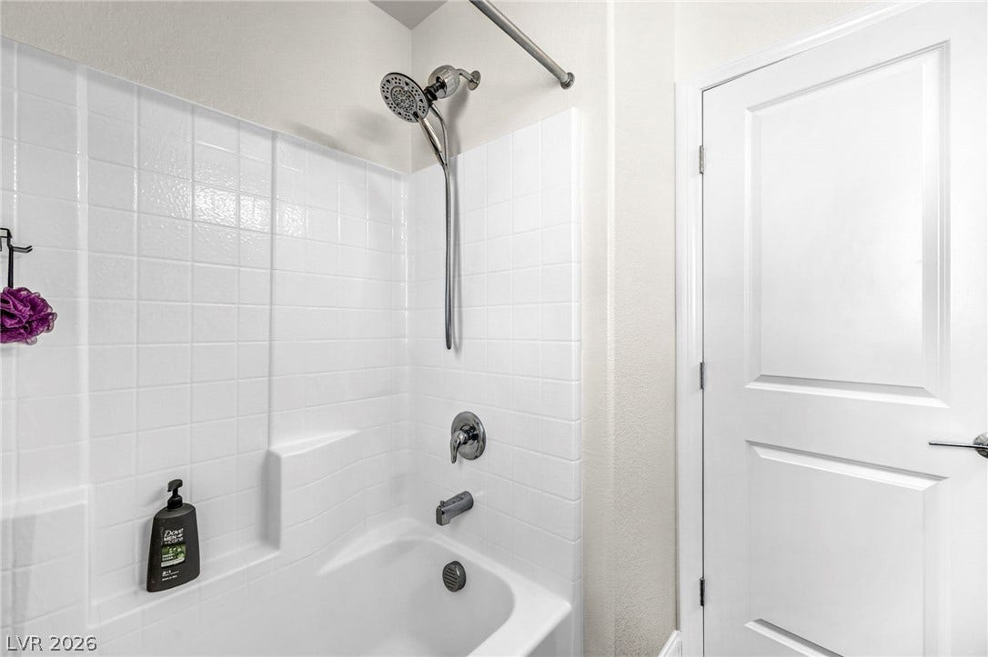 2594 Canary Yellow Court, North Las Vegas, NV 89086 An immaculate tub and shower surround stands beside a classic paneled interior door.
