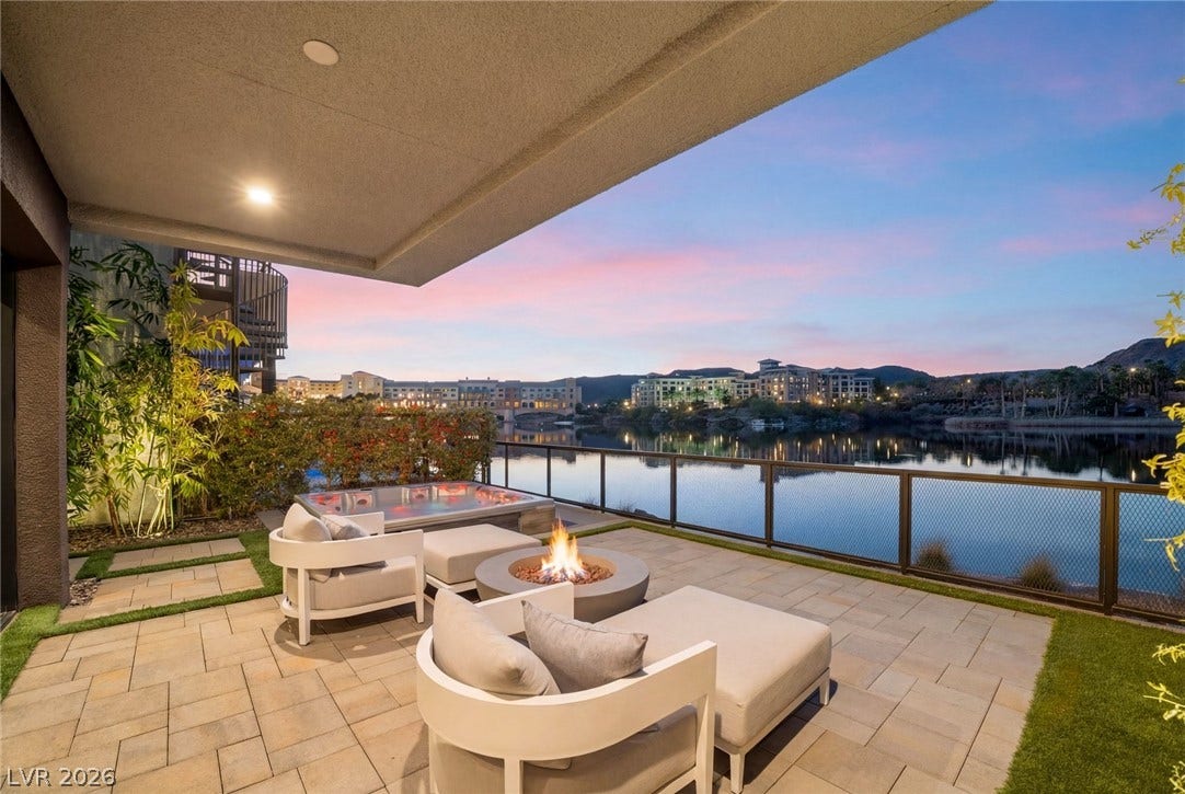 34 Lakefront Drive, Henderson, NV 89011 A spacious covered patio overlooks the tranquil water against a colorful twilight sky.
