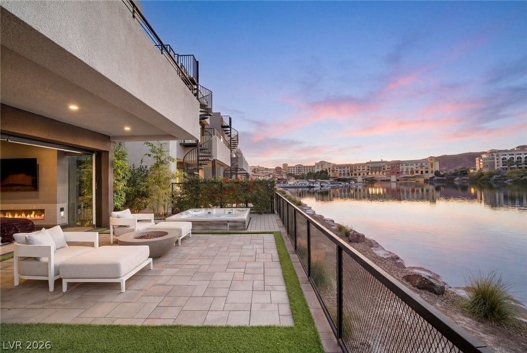 34 Lakefront Drive, Henderson, NV 89011 A spacious stone patio overlooks serene waterfront vistas under a dramatic evening sky.