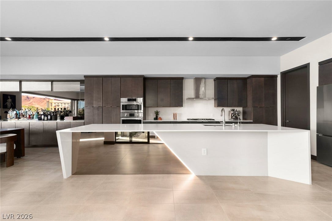 34 Lakefront Drive, Henderson, NV 89011 A minimalist kitchen showcases a massive geometric island, flat-panel cabinetry, and modern integrated appliances.