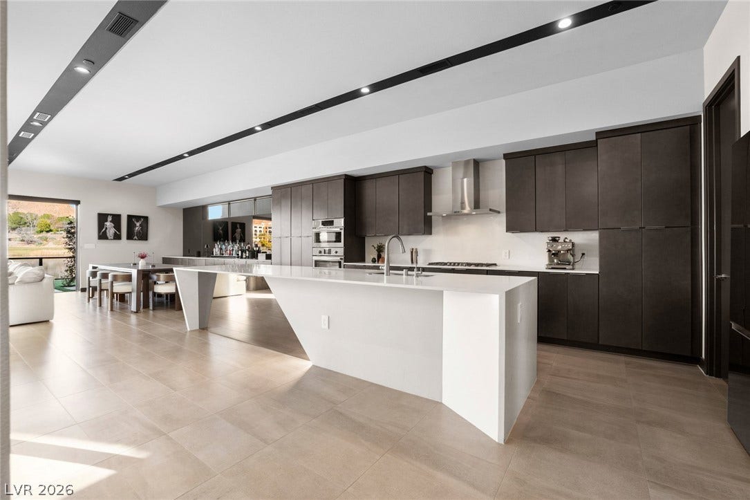 34 Lakefront Drive, Henderson, NV 89011 An angular statement island and sleek modern cabinetry anchor this open-concept kitchen.