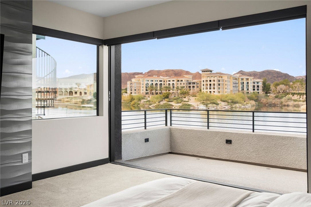 34 Lakefront Drive, Henderson, NV 89011 Massive sliding glass doors open onto a private balcony overlooking the scenic lake and mountains.