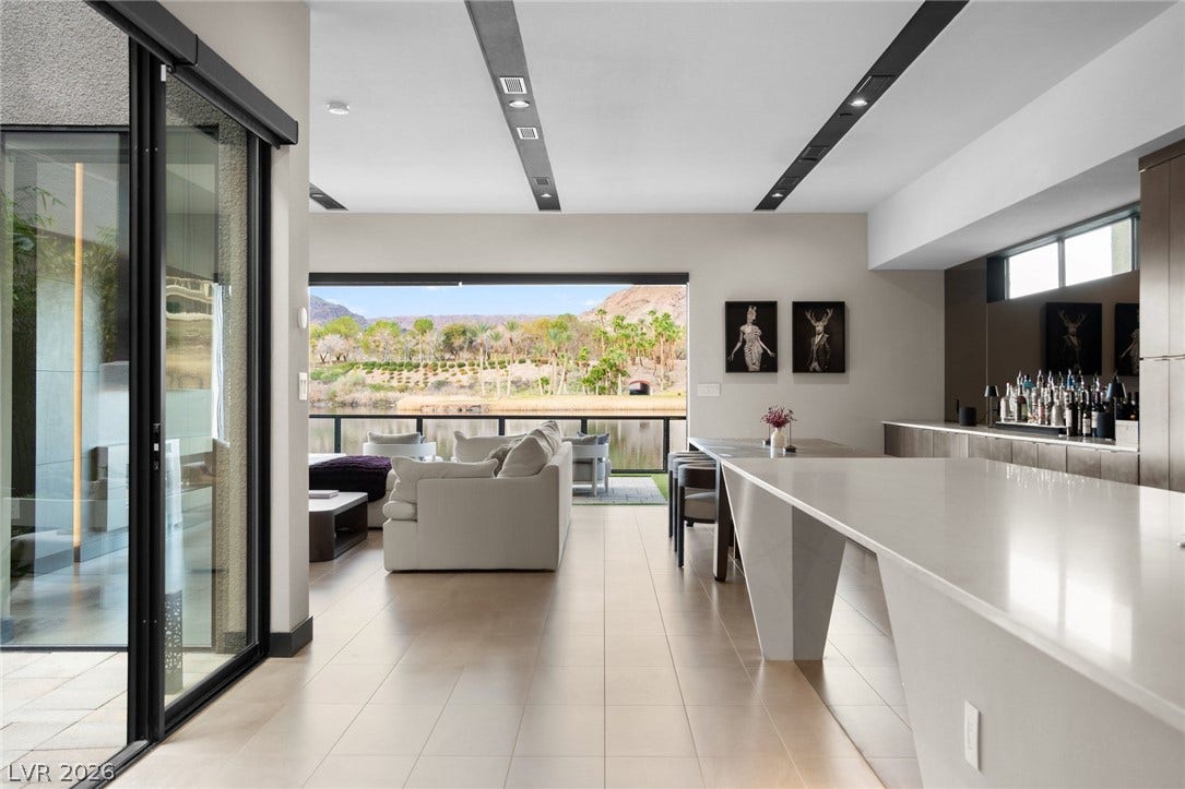 34 Lakefront Drive, Henderson, NV 89011 Smooth tile flooring, clean linear recessed lighting, and expansive glass doors overlook a peaceful waterfront.