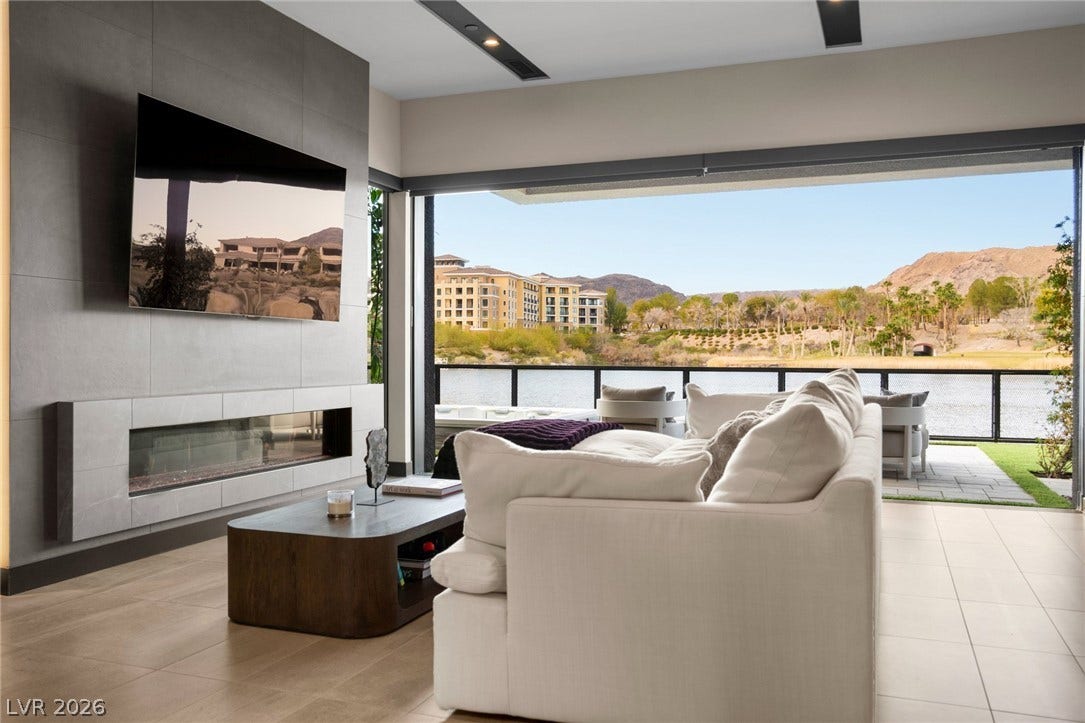 34 Lakefront Drive, Henderson, NV 89011 Retractable glass doors connect the tiled living area to a scenic waterfront patio.