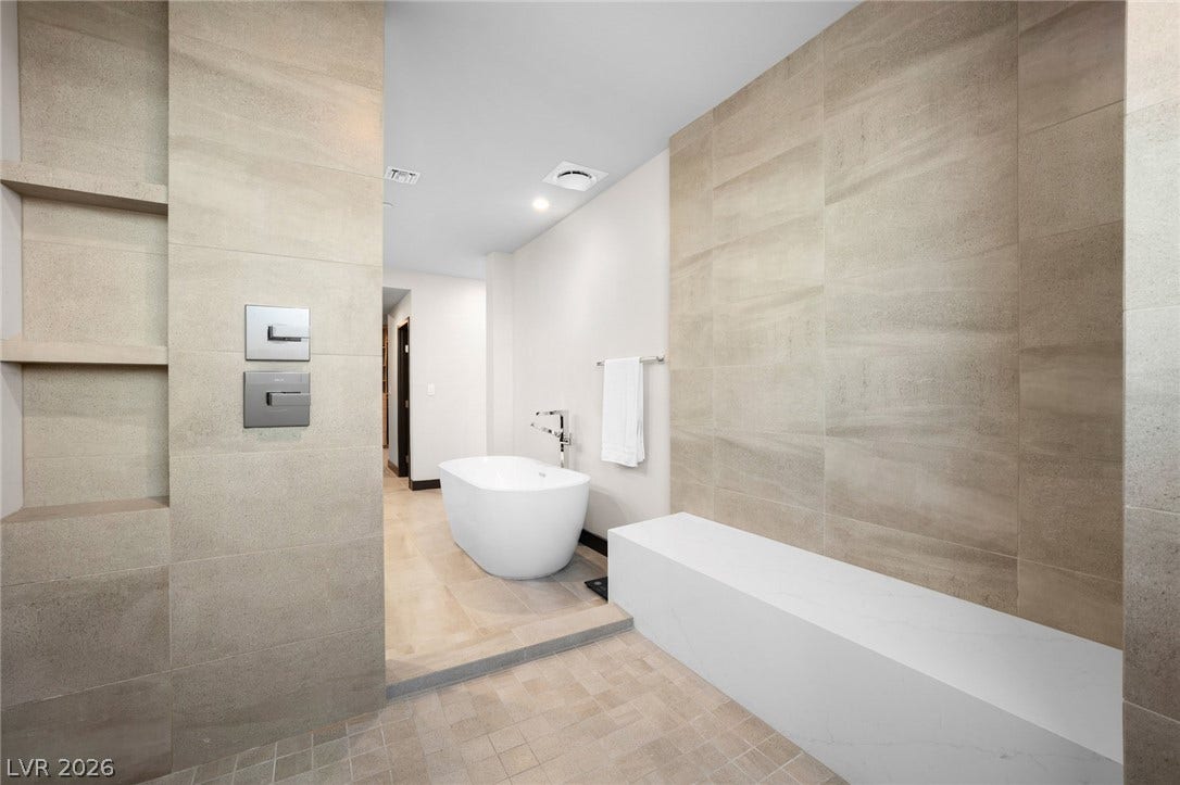 34 Lakefront Drive, Henderson, NV 89011 Floor-to-ceiling tiling and a built-in bench elevate this modern wet room design.