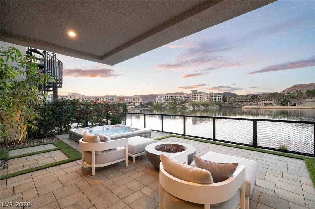 34 Lakefront Drive, Henderson, NV 89011 A spacious stone patio overlooks the tranquil water and surrounding mountain landscape.