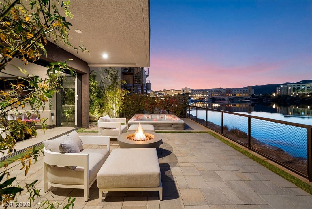 34 Lakefront Drive, Henderson, NV 89011 An expansive paved patio overlooks tranquil waters under a vibrant evening sky.