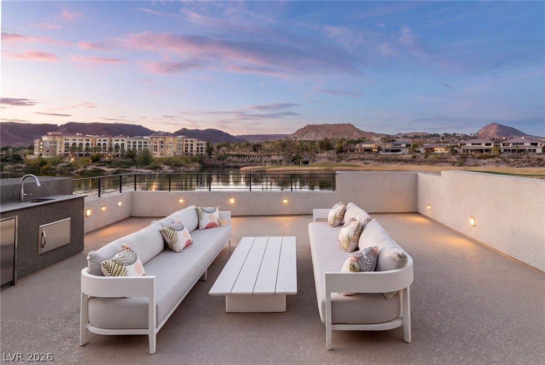 34 Lakefront Drive, Henderson, NV 89011 A spacious rooftop terrace overlooks peaceful waters and distant mountains under a twilight sky.